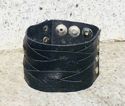 Leather wristband handmade from black leather plaited and secured with chrome finished press studs.