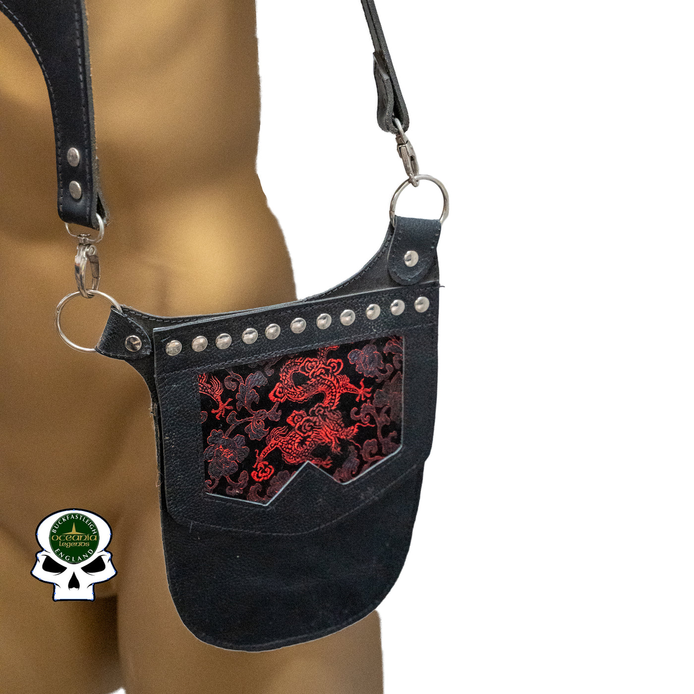 Real Leather back holster to keep your belongings and vaulables safe.  It has an adjustable strap with buckles at the front with chrome effect studs in various places, rings that sit on the shoulders and another buckle securing at the back.  on the side is a decorative pouch for your valuables to keep them out of site.  This one has a red dragon design on the pouch
