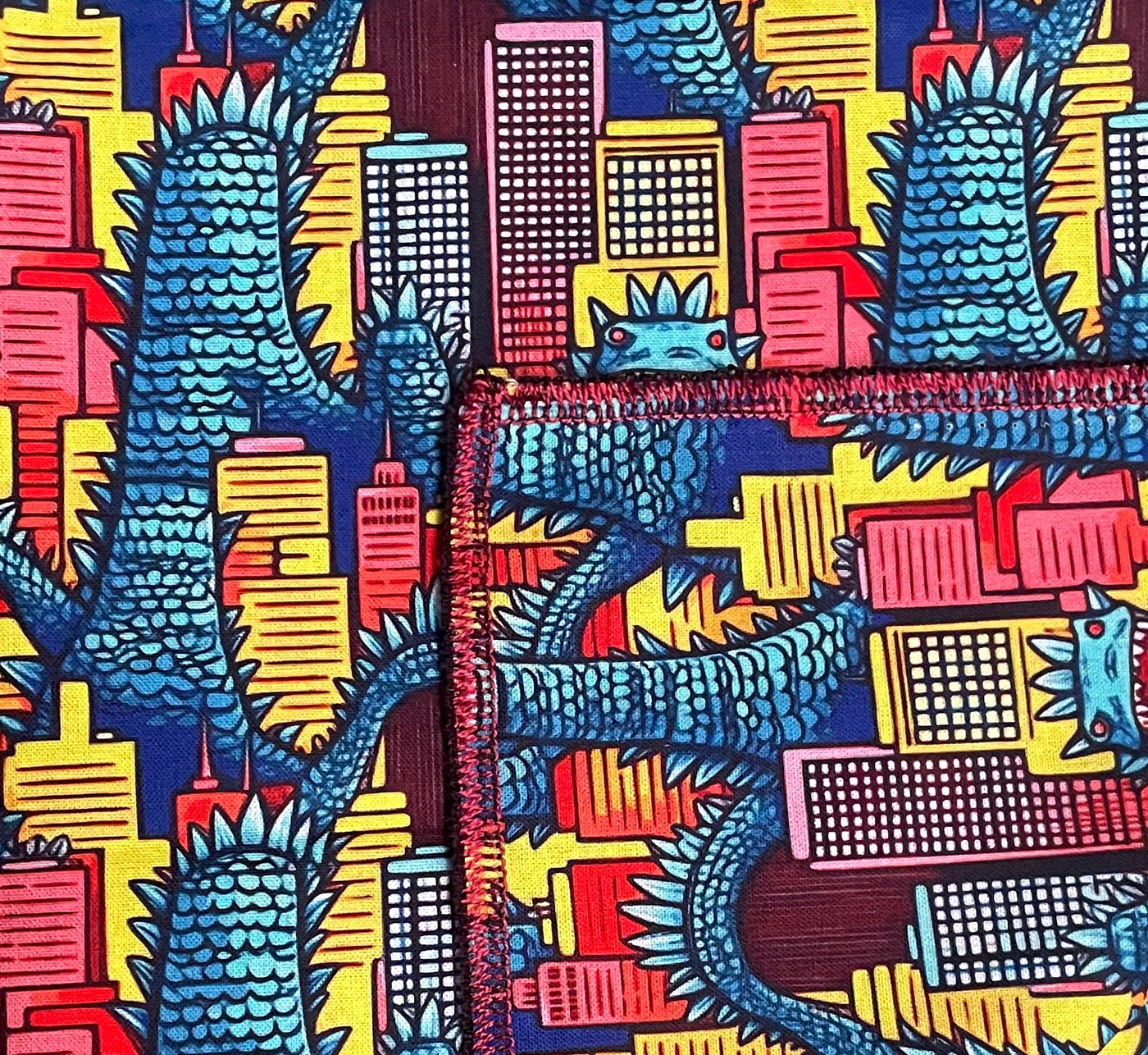 Dinosaur at large in the city design on our handmade bright cotton bandana approx. 21.5" x 21.5"