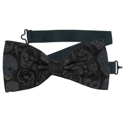 Black Bow tie with skulls in a random pattern with a couple of small cross & arrows dotted around.  The bow tie is handmade from 100% cotton, pre-tied with a sliding ribbon with a hook to attach at the back of your neck or collar.