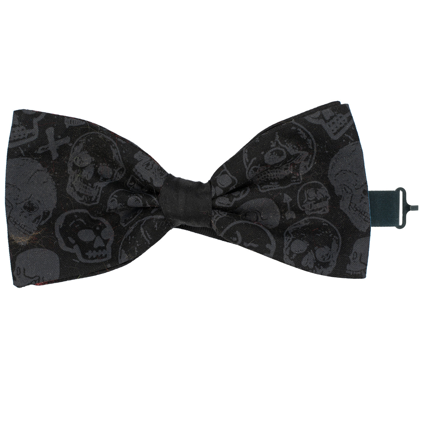 Black Bow tie with skulls in a random pattern with a couple of small cross & arrows dotted around.  The bow tie is handmade from 100% cotton, pre-tied with a sliding ribbon with a hook to attach at the back of your neck or collar.