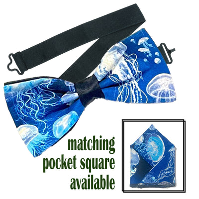 Lovely design with swarms of jellyfish swimming on a sea blue fabric.  Handmade bow tie & pocket square.  The bow tie is on a sliding ribbon to easily attach. The pocket square is  25 cmx 25 cm, pre-tied so just pop it straight in your pocket. Cotton
