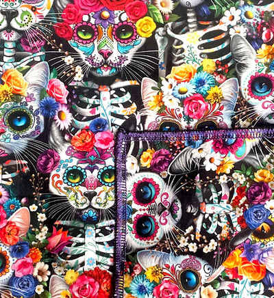 Handmade bandana, with skeleton cats decorated in day of the dead designs surrounded in flowers and wearing floral headdresses. You can wear our bandana as a thin band or wrap it to cover your entire head, great for sun cover.  You can even wear it as a neckerchief or wrist wrap.  It is approx. 21.5" x 21.5" 100% machine washable cotton from Timeless Treasures
