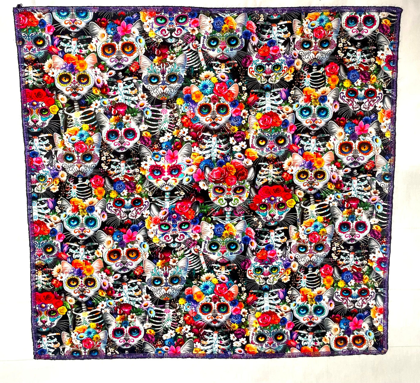 Handmade bandana, with skeleton cats decorated in day of the dead designs surrounded in flowers and wearing floral headdresses. You can wear our bandana as a thin band or wrap it to cover your entire head, great for sun cover.  You can even wear it as a neckerchief or wrist wrap.  It is approx. 21.5" x 21.5" 100% machine washable cotton from Timeless Treasures
