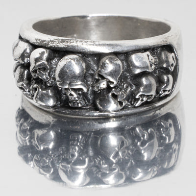 Cluster of 13 skulls on a 925 sterling silver ring band.  Out of the 13 there is 1 large skull in the centre with 3 rows of 2 skulls on either side
